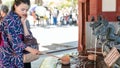 Japanese woman washing hands at a dragon fountain at Sensoji Asakusa Kannon Temple, Tokyo, Japan Royalty Free Stock Photo