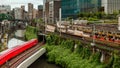 TOKYO, JAPAN - AUGUST 09 2023: Long exposure image of subway and rail trains passing over the Kanda River at the