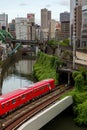 TOKYO, JAPAN - AUGUST 09 2023: Trains passing a busy intersection and tunnel over the Kanda River at the Hijiribashi Bridge, Tokyo