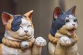 Aum pair of closed-mouthed and open-mouthed statues of Maneki-neko cats.