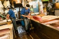 Tokyo, Japan - January 15, 2010: Early morning at Fish Market. Two vendors cutting tuna at Tsukiji Fish Market