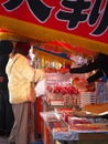 A lady buys a sugar coated apple at a street stand