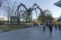 People walk around Maman spider sculpture at Roppongi Hills in Tokyo, Japan