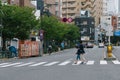 Tokyo, Japan - August 15, 2020 : asian japanese mother using a mobile phone or smartphone to search for information while crossing