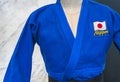 Japanese blue Judo uniform adorned with Japan national flag and word Nippon.