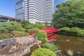 Japanese Taikobashi bridge crossing the pond of the Hotel New Otani Japanese Garden. Royalty Free Stock Photo