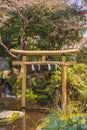 Golden torii gate decorated with a shimenawa rope in the basin of the Atago sanctuary.