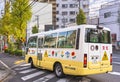 Japanese kindergarten school bus and warning road sign on a pedestrian crossing.