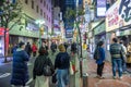 People walking along a side street around Shinjuku station at night