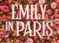 Title of romantic comedy-drama tv series Emily in Paris against a roses background.