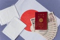 Abenomask cloth masks, 100000 yen in cash and japanese passport on a Japan flag.