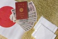 Cloth masks, 100000 yen in cash with a passport on a Japan flag and golden paper.