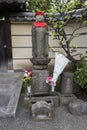 Tokyo,Japan - Peaceful stone religious Jizo statue with red hat