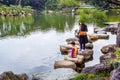 Mother and son watching on KOI carps. Fine garden with artificial