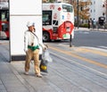 TOKYO, JAPAN - NOVEMBER 7, 2017: A man collects garbage on a city street. Copy space for text.