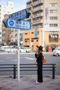 TOKYO, JAPAN - November 13 , 2017 : Tourists girl look at street sign to Buddhist Temple Sensoji, Japan. The Sensoji temple in Asa