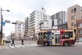 Tokyo, Japan - November 17, 2017 : Two Japanese men are crossing pedestrian lane while Japanese bus is stopping on the road. Japan