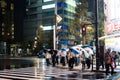 Tokyo, Japan - October 5, 2018: businessmen and women opened their umbrellas as the rain pours at night