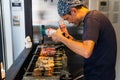 A Man Is Cooking Fresh Tuna Sticks On A Grill Royalty Free Stock Photo