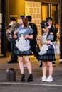 Tokyo, Japan - October 15, 2022: Cute girds cosplay on night streets of Tokyo displaying ads Royalty Free Stock Photo