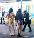 Tokyo, Japan - October 15, 2022: Cute girds cosplay on night streets of Tokyo displaying ads Royalty Free Stock Photo