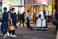 Tokyo, Japan - October 15, 2022: Cute girds cosplay on night streets of Tokyo displaying ads Royalty Free Stock Photo