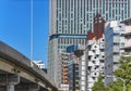 The iconic Nakagin Capsule Tower building aside the Shuto Expressway overlooked by skyscrapers.