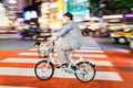 Night panning photography of unidentified man with a dog riding bicycle at Shibuya Square.The one