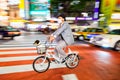 Night panning photography of unidentified man with a dog riding bicycle at Shibuya Square.The one