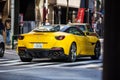 Tokyo, Japan, 26 October 2023: Rear View of a Yellow Sports Car on a Busy Tokyo Street