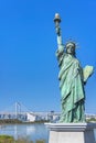 Replica of the Statue of Liberty on the bayside of Odaiba with the Rainbow Bridge in background.