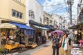 Tourists strolling in Yanaka Ginza street with traditional stores of geta straw sandals.