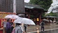 Elderlies with umbrellas a rainy day buying takoyaki octopus balls in Sugamo Jizo shopping street.