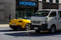 Tokyo, Japan, 26 October 2023: Yellow Sports Car and Delivery Truck on Tokyo Street