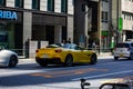 Tokyo, Japan, 26 October 2023: Yellow Sports Car Driving Past Horiba Office Building