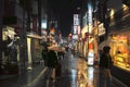 Tokyo, Japan - 11/6/2018: People walking down a wet street in Koenji at night