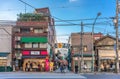 People strolling in the Komagome district beneath the metallic arch of Shimofuri shopping street.