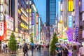 Tokyo, Japan - Sep 28th 2018 - Tourists and locals walking in a wet road full of colorful billboards in a late afternoon in Japan