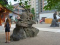 European girl travels in Asia. Lion-dog is an image of a guardian dedicated to the area surrounding a shrine