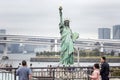 Tokyo, Japan, 04/08/2017: Statue of Liberty on Odaiba Island in blooming sakura on a gloomy day Royalty Free Stock Photo