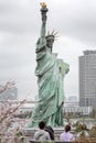 Tokyo, Japan, 04/08/2017: Statue of Liberty on Odaiba Island in blooming sakura on a gloomy day. Royalty Free Stock Photo