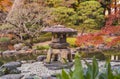 Tokyo Metropolitan Park KyuFurukawa`s japanese garden`s Yukimi stone lantern overlooking by red maple momiji leaves in autumn.