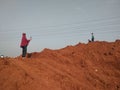 Tol cibitung Cilincing, Bekasi, Indonesia - (16-08-2020) : Local residents are playing on a pile of red dirt