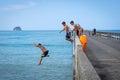 Local boys jumping of Tolaga Bay Wharf