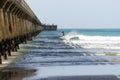 Surfer riding waves by Tolaga Bay Wharf Royalty Free Stock Photo