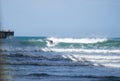 Surfer riding waves by Tolaga Bay Wharf Royalty Free Stock Photo