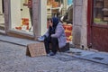 Toledo, Spain; December 23 2.017: A sad unidentified homeless woman sitting in a cardboard box asking begging for money to eat the