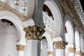 White octagonal pillars and arcades with golden floral capitals in the Synagogue of Santa Maria la Blanca, Toledo, Spain.