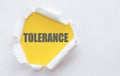 Tolerance text on a yellow background under white torn paper. Equality, diversity and tolerance concept Royalty Free Stock Photo