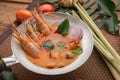 Tom yam kong or Tom yum, Tom yam is a spicy clear soup typical in Thailand Cuisine. Tom yam kong on wooden table. Thai food Royalty Free Stock Photo